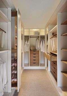 an image of a walk in closet with clothes on the shelves