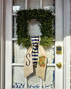 two burlocks with monogrammed letters hang on the front door to welcome guests