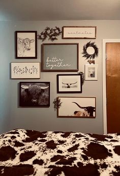 a bedroom with pictures on the wall and cow print bed spread in front of it