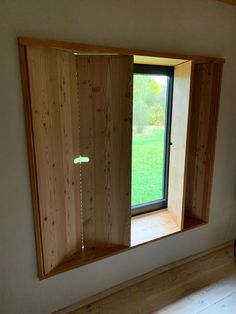 an open window in the corner of a room with wood paneling on the walls