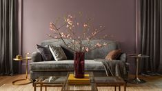 a living room filled with furniture and a tall vase on top of a coffee table