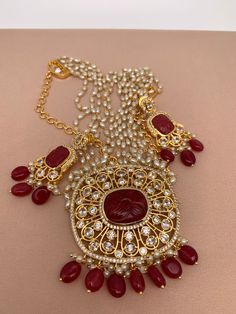 Red Stone CZ Red Beads and Rice Pearl Long Rani Haar with Matching EarringsColor : GoldenSize : Necklace Length : 26 Inches; Earring Length 2.25 inchesStones : Red Stone and Pearl Red Monalisa Beads CZ Pearls Red Ruby Jewelry Sets For Gifts, Red Ruby Jewelry Sets As Gift, Red Beaded Pendant Necklace, Red Kundan Jeweled Earrings, Red Jeweled Kundan Earrings, Red Kundan Necklace With Round Beads For Party, Red Beaded Temple Jewelry Sets, Red Jewelry Sets With Round Beads For Festivals, Red Jewelry Sets With Round Beads For Gift