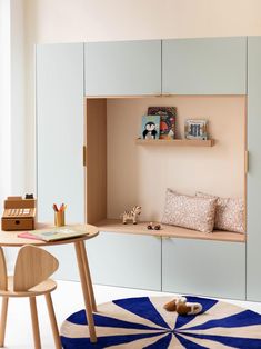 a child's playroom with blue and white rugs, bookshelves and toys