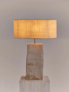 a lamp that is sitting on top of a block of wood with a light on it