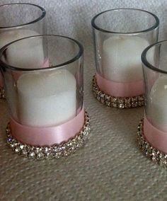 three pink and white candle holders with crystal beads on the sides, one is filled with candles