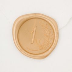 a wax stamp with the number one on it and a laurel design is placed in front of a white background