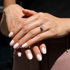 a woman's hands with white manies and a ring