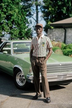 a man standing in front of a green car