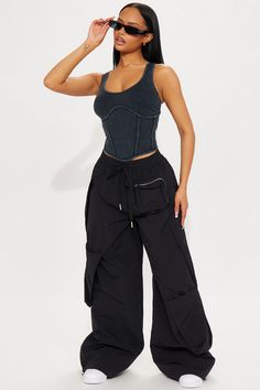 a woman wearing black pants and a crop top