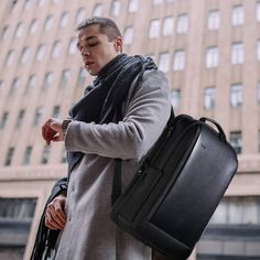 a man in grey coat carrying a black briefcase