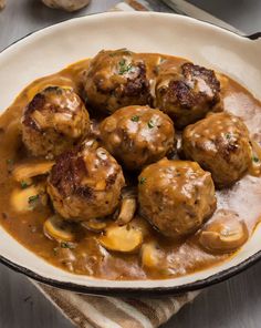 some meatballs and gravy in a white bowl