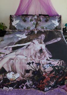 a bed covered in purple sheets with a painting on the comforter and pillow cases