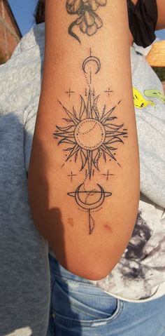 a woman's arm with a tattoo on it that has an image of the sun and moon