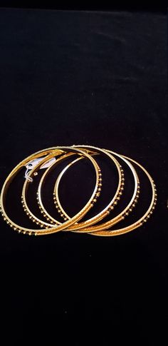 "* Handcrafted Gold Plated 4 Bangle Set. Sold as a set. * Bangles with pretty black beads and gold beads * High Quality 22 K Gold Plated- 4 Bangle set * Size 2.6 has 2.40\" inner circle diameter; Size 2.8 has 2.52\" inner circle diameter Gorgeous gold-plated bangle/ bracelet best exemplifies the careful craftsmanship done on it -- a specialty at Nemali Jewelry. It has a special tone of elegance attached to it. The intricate handmade design of the bangle/bracelet set gives it a fresh and original Gold Beaded Bangle Jewelry, Gold Bangle With Round Beads For Wedding, Stackable Gold Jewelry For Festivals, Gold Stackable Bracelets For Festivals, Traditional Gold Beaded Round Bracelets, Gold Festive Bangle, Gold Bangle Beaded Bracelets For Festivals, Gold Beaded Bangle Bracelet For Festivals, Black Beads Bangles