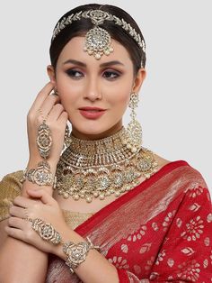 This jewelry set consists of a necklace, a pair of earrings, 2 hathphool bracelets and matha pattiGold-plated necklace has white kundan-studded and white pearls beaded detailsSecured with a drawstring closureA pair of matching drop earrings, each secured with a post-and-back closure2 matching hathphool bracelets, secured with a s-hook closureA matching Matha patti, secured with a hook closure Size & Fit Size of the necklace: 24 cm x 12 cm (Length x Width)Size of the earrings: 11 cm x 5.5 cm(Length x Width)Size of the Mathapatti: 11 cm x 23.5 cm(Length x Width)Size of the Hathphool: 13 cm x 16 cm (Length x Width) Material & Care Material: AlloyPlating: Gold-platedStone Type: Kundan and Beads Care InstructionsWipe your jewellery with a soft cloth after every useAlways store your jewellery in Luxury Festive Jewelry Sets With Latkans, Luxury Cutdana Tikka For Reception, Chandbali Jewelry Sets For Puja, Kundan Bridal Necklace With Latkans, Traditional Kundan Bridal Necklace With Latkans, Hand Set Ceremonial Jewelry For Navratri, Ceremonial Hand Set Jewelry For Navratri, Ceremonial Hand-set Jewelry For Navratri, Chandbali Bridal Sets With Tilla Detail