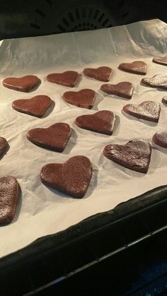 some heart shaped cookies are sitting on a baking sheet and ready to go into the oven