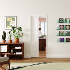 a living room filled with furniture and pictures hanging on the wall above a door way