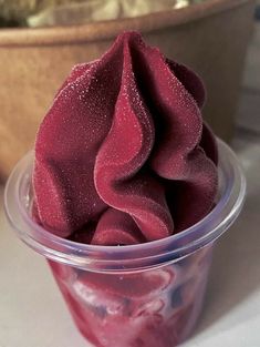 a plastic cup filled with red liquid on top of a table