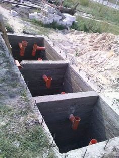 there are three cement troughs in the ground that have been dug into the ground