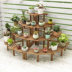 a wooden plant stand filled with potted plants