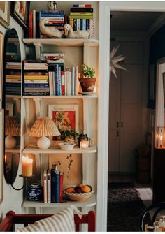 a living room filled with furniture and bookshelves next to a doorway leading into a dining room