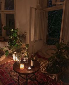 a living room with plants and candles on the table