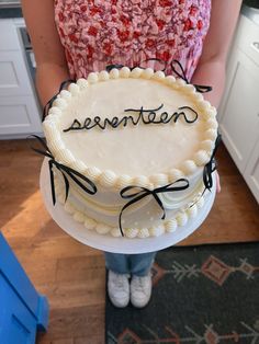 a woman holding a cake with writing on it