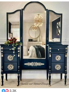 a blue dresser with a mirror on top and flowers in the bottom drawer next to it