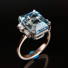 an aquamarine colored diamond ring with diamonds on it