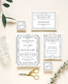 the wedding stationery is laid out on top of the table with scissors and greenery