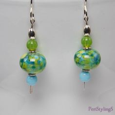 "These cheerful earrings are like a breath of Spring air! The focal beads made by a Georgia USA artist, have lovely shades of fern green and sky blue. Below are Cz glass sky blue round beads and above are Cz glass mantis green round beads. Set off with silver accents, the earrings hang 2\"(5 cm) from the top of the sterling silver handmade ear wires to the tip of the silver paddle pins. Comes in a beautiful gold or silver gift box, wrapped in a white iridescent fabric bag. Ready for gift giving, Hypoallergenic Beaded Earrings With Round Beads For Summer, Elegant Green Hypoallergenic Beaded Earrings, Green Dangle Glass Earrings, Green Glass Dangle Earrings, Green Beaded Earrings With Round Beads, Green Beaded Earrings For Summer, Hypoallergenic Czech Glass Round Earrings, Hypoallergenic Round Czech Glass Earrings, Summer Green Nickel-free Earrings