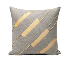 a grey and gold striped pillow on a white background