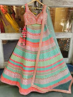 This multicolored banarsi, chanderi silk mixed panelled lehenga is paired with a rainbow mirror work choli.  The outfit is completed with a mint net mukaish dupatta.
NOTE: Ready-to-Ship in a size Medium. Ships in 3 days. Green Chanderi Lehenga With Cutdana, Multicolor Chanderi Anarkali Set For Reception, Bohemian Pista Green Anarkali Set For Diwali, Festive Pista Green Bohemian Anarkali Set, Multicolor Semi-stitched Anarkali Set For Designer Wear, Anarkali Style Multicolor Sharara With Cutdana, Designer Multicolor Bohemian Sharara, Designer Bohemian Multicolor Sharara, Multicolor Anarkali Set With Gota Work