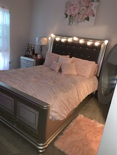 a bedroom with a large bed and pink rugs on the floor in front of it