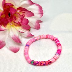 Add a pop of color and a touch of charm to your wrist with this handmade polymer clay beaded bracelet. This lovely piece features a perfect blend of pink and purple spacer beads, creating a delightful contrast that will add a playful and feminine flair to any outfit. Whether you're looking for a unique accessory for yourself or a thoughtful gift for a friend, this friendship bracelet is sure to bring joy and sweet style to your day. Made with care and attention to detail, each bead is uniquely crafted to ensure a one-of-a-kind piece that you'll love to wear on repeat. Playful Pink Beaded Bracelets, Pink Hand-strung Heishi Beads Friendship Bracelets, Pink Heishi Beads Bracelets With Colorful Beads, Pink Heishi Beads Colorful Beaded Bracelets, Handmade Pink Heishi Beads Stretch Bracelet, Colorful Beaded Polymer Clay Friendship Bracelets, Pink Heishi Beaded Bracelets With Colorful Beads, Pink Heishi Beads Bracelet With Colorful Beads, Playful Pink Bracelets With Round Beads