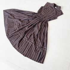 "One of the very first few vintage pieces I ever bought. This is such a timeless piece. Brown and white pinstripes with a sleeveless button down front and the most adorable of bows on the hem. The bow breaks the vertical running lines to great effect. Simple. Classy. Condition: Excellent Label: Tailored Juniors Bust 38\" Waist 25\" Length 43\" This is clean and ready to wear. Comes from a smoke and pet free home. Don't forget to follow me on Instagram @tammaraclearshercloset for new listing aler Grecian Goddess, 1950’s Fashion, Peacock Dress, Tea Length Dresses, 50s Dresses, New Vintage, Timeless Pieces, Dress Clothes For Women, Beautiful Dresses