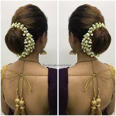 the back of a woman's head with flowers in her hair and pearls on it