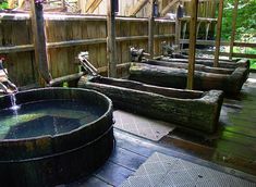 an outdoor hot tub with water coming out of it and wooden benches in the background