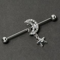 Product Details14 Gauge Clear CZ Gem Moon Dangle Star Industrial Barbell 38mm Give your industrial piercing a look as lovely as the night sky with this 14 gauge helix barbell. It is made with a 1 1/2 inch 316L surgical grade stainless steel straight barbell with 5mm ball ends. It features a crescent moon charm, embellished along the edge with clear cubic zirconia gems and tiny stars. Dangling beneath is another star with a clear cubic zirconia gem at the center. You can even slide it up and down Moon Industrial Piercing, Industrial Bar Piercing, Industrial Piercing Jewelry, Conch Piercing Jewelry, Opal Nose Ring, Daith Piercing Jewelry, Tragus Piercing Jewelry, Pregnancy Belly Rings, Horseshoe Jewelry