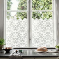 a kitchen window with an intricate screen behind it