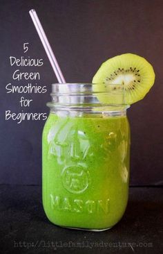 a green smoothie in a mason jar with a straw and kiwi on top