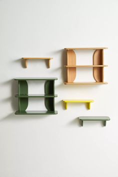 three shelves on the wall with different colors and shapes, one is green, the other is yellow