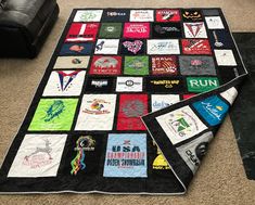 a black couch sitting on top of a carpet covered in patches and t - shirts