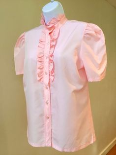 "This 90's sweet blush pink puffed sleeve Dacron blouse from \"Lucky Winner\" has a soft ruffle neck and front placket. The ruffle extends halfway down the front button closure. Perfect with jeans or a skirt!  Please check your measurements as vintage sizes are often different from contemporary sizes.  This blouse is medium to large. Very good vintage condition! Armpit to pit flat measurement, 20\" Length from shoulder, 25\"" Retro Pink Button-up Top, Pink 90s, Feminine Pink Button-up Blouse, Vintage Pink Blouse With Button Closure, Vintage Button-up Ruffled Blouse, Pink Ruffled Button-up Blouse, 90s Shorts, Rose Blush, Wiggle Dress