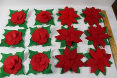 felt flowers are laid out on a table to be made into christmas wreaths and decorations