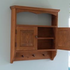 a wooden cabinet mounted to the side of a wall