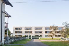 the building has many windows and doors on each side of the walkway that leads to an entrance