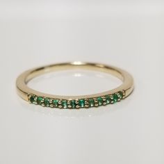 "Thanks for shopping our vintage estate store. We tend to sell well below wholesale and truly hope you enjoy all of our items. Many of the items are one of a kind, so please enjoy scrolling through the pictures and hopefully something will catch your eye. Black spots are from camera or reflections. Beautiful estate 14k yellow gold natural .10ct green, emerald ring or band. There are 12 natural emeralds in setting. Ring size: 8 Setting: 1/16\" 1.7mm Band width: 1.5mm Weight: 1.90 grams Marked 14k, one that someone will love." Emerald Eternity Band In Yellow Gold As Gift, Classic Formal Stackable Birthstone Ring, Yellow Gold Emerald Eternity Band As A Gift, Classic Green Stackable Rings For Formal Occasions, Classic Stackable Rings For Anniversary, May Birthstone, Timeless Diamond Ring For Anniversary, May Birthstone, Timeless Diamond Ring For Anniversary With May Birthstone, Gold Jewelry For May Birthstone With Half Eternity, Gold Half Eternity Jewelry For May Birthstone