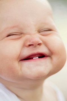 a close up of a smiling baby with toothpaste on it's teeth