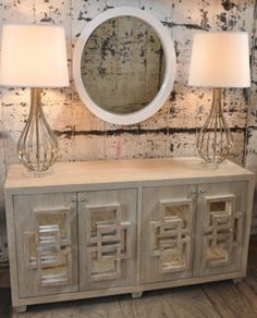 an image of a table with lamps and a mirror on the sideboard in front of it